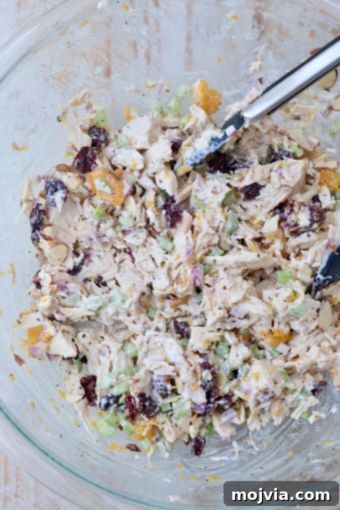 Garden Chicken Medley 5 finished chicken salad in a large glass bowl, ready for serving, with kitchen tongs