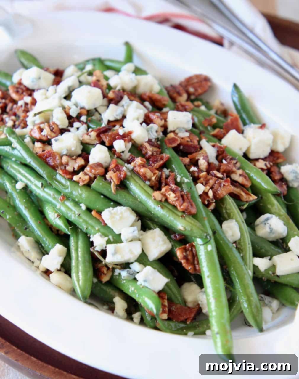Green Beans with a Bacon, Pecan and Blue Cheese Crunch 4 Fresh green beans in serving bowl, topped with pecans and blue cheese crumbles