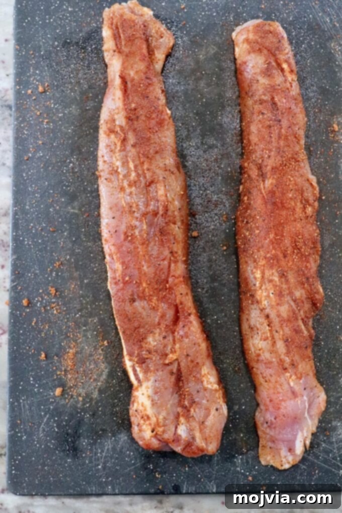 Perfectly Smoked Pork Tenderloin 4 seasoned pork tenderloins on cutting board