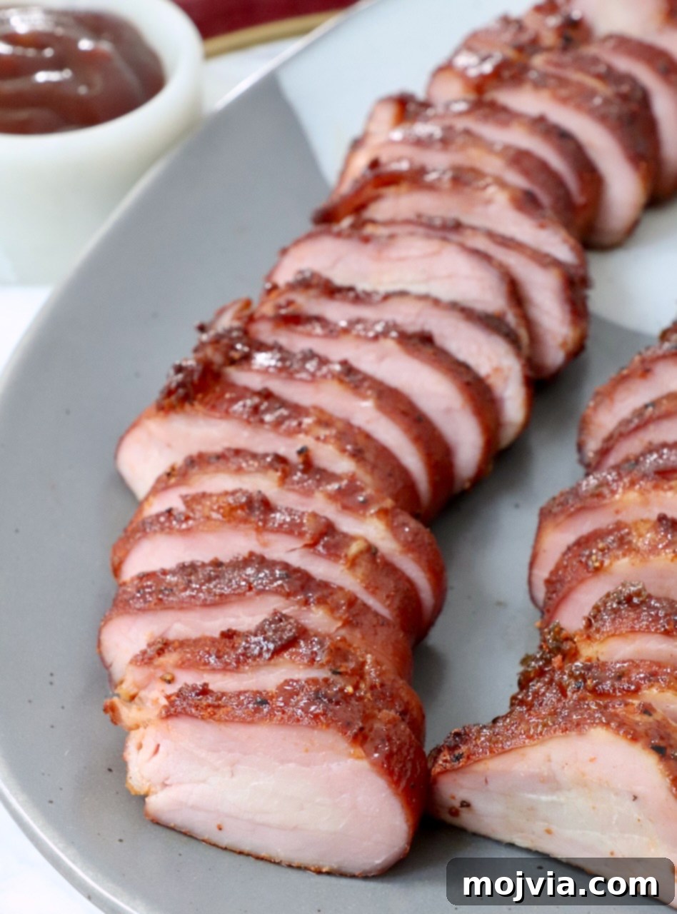 Perfectly Smoked Pork Tenderloin 9 sliced smoked pork tenderloin on plate