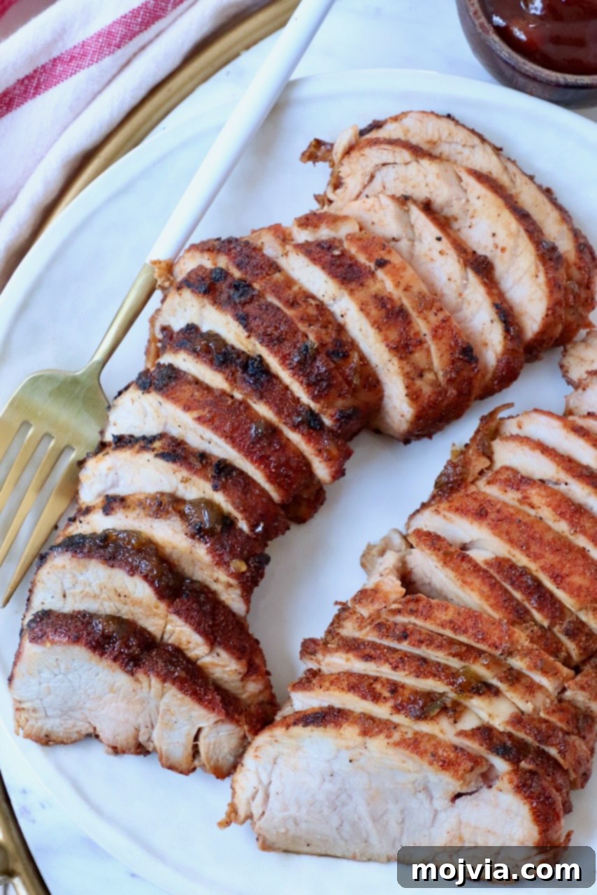 Fire-Kissed Pork Tenderloin 8 Close-up of perfectly sliced grilled BBQ pork tenderloin presented on a plate, ready to be enjoyed.