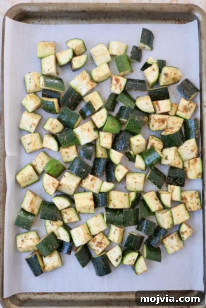 Mastering Zucchini: Your Essential Cooking Guide 7 seasoned diced zucchini on parchment lined baking sheet