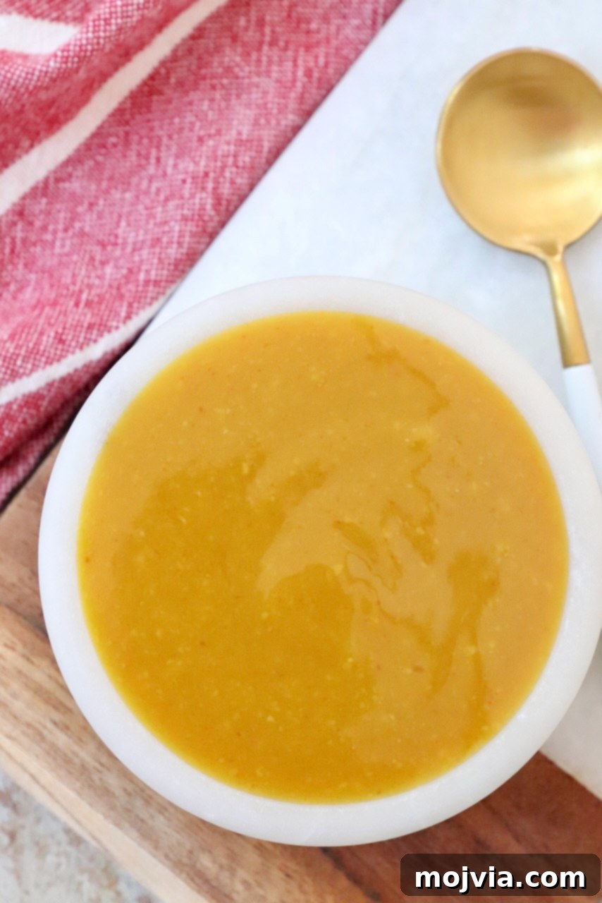 Carolina Gold Mustard Magic 6 mustard bbq sauce in small bowl with spoon