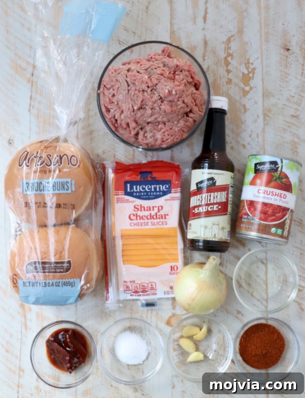 Robust Chili Burger 3 Ingredients for making chili cheeseburgers laid out on a white wooden board