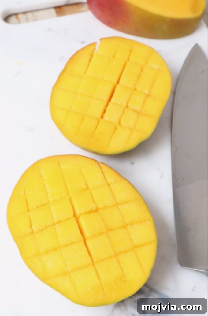 The Art of Mango Slicing 5 Mango cheek scored into a grid pattern with a knife, ready for scooping