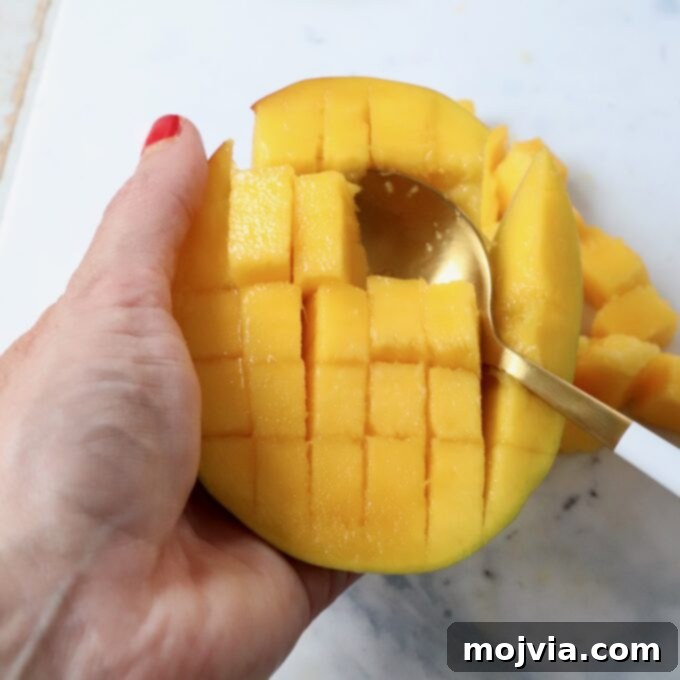 The Art of Mango Slicing 7 Mango cubes cleanly scooped out of the skin, resting in a bowl with a spoon