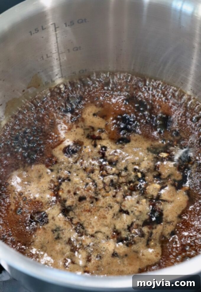 Umami Glaze 4 Teriyaki sauce gently bubbling in a saucepan on the stove, indicating it's reaching the desired cooking temperature.