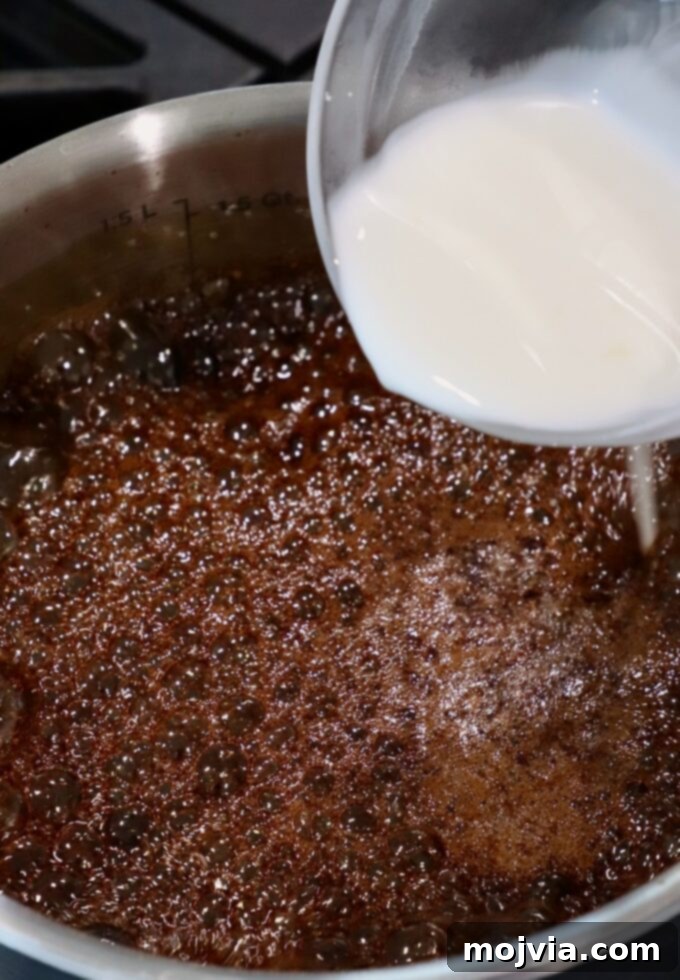 Umami Glaze 5 A cornstarch slurry being poured into the simmering teriyaki sauce in a pot on the stove, a crucial step for thickening.