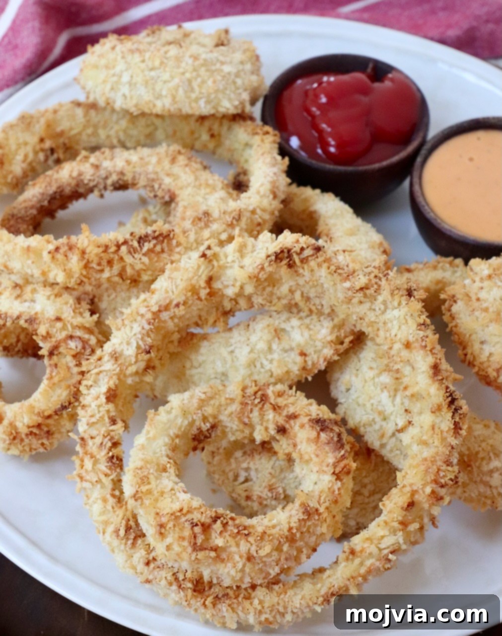 Golden & Crispy Air Fryer Onion Rings 2 cooked onion rings on plate, golden brown and perfectly crispy