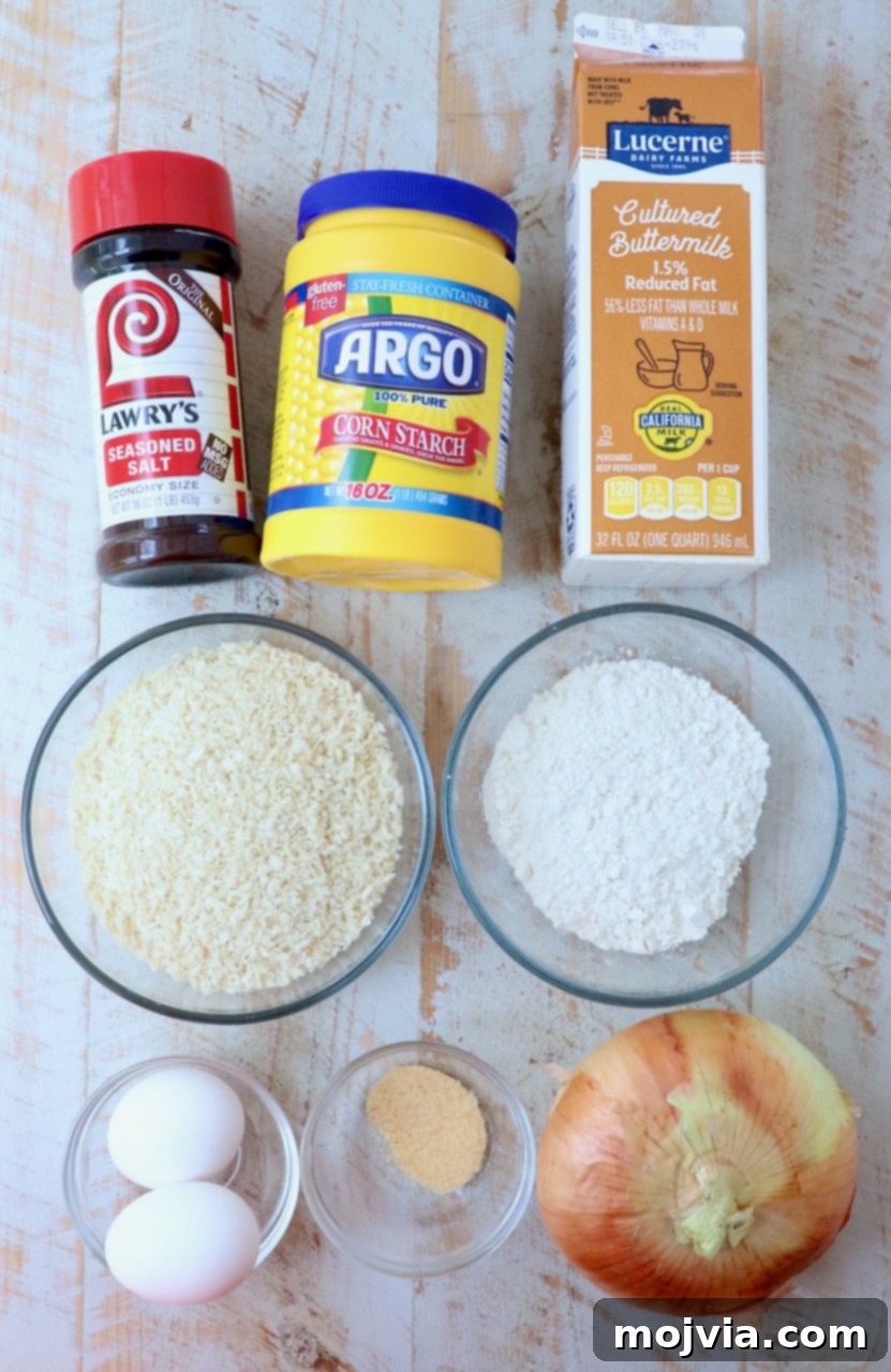 Golden & Crispy Air Fryer Onion Rings 3 ingredients for air fryer onion rings laid out on a white wooden board