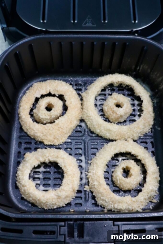 Golden & Crispy Air Fryer Onion Rings 10 coated onion rings arranged in a single layer in an air fryer basket