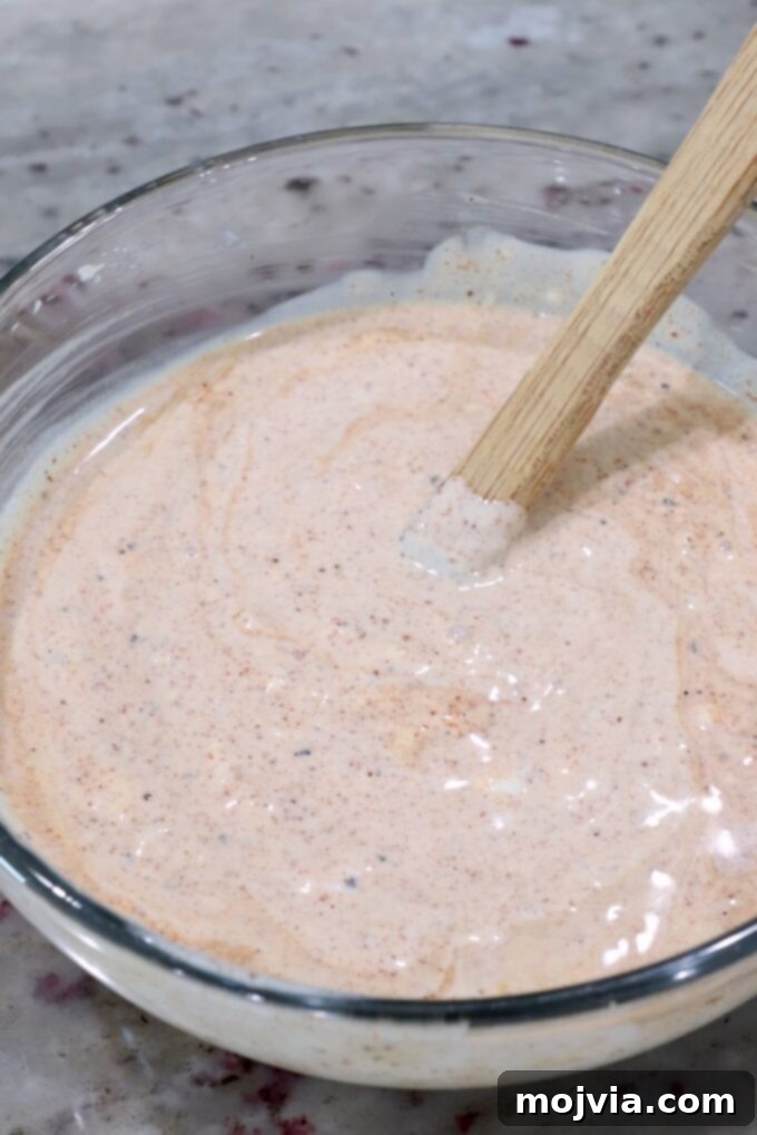 Creamy chili lime dressing prepared in a small glass bowl with a spatula, showcasing its smooth texture.