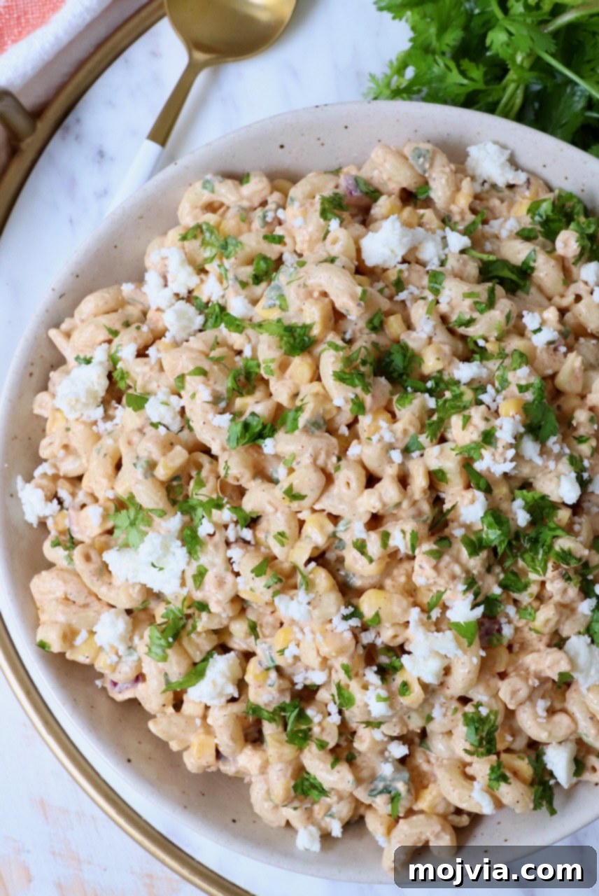 A serving of Mexican street corn pasta salad in a small individual bowl, garnished for presentation.