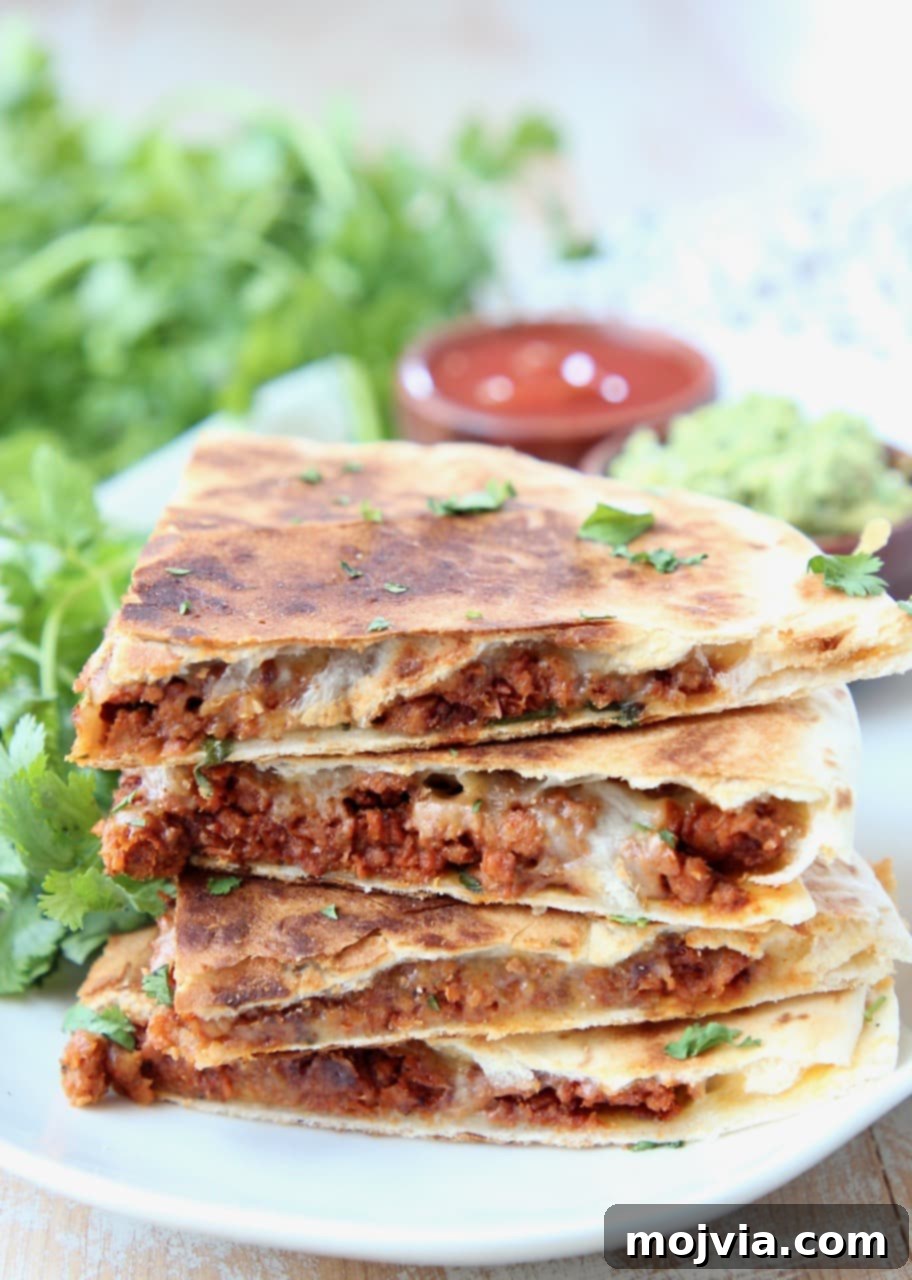 Zesty Soy Chorizo Fold 2 Soy chorizo quesadilla slices stacked up on a plate with fresh cilantro