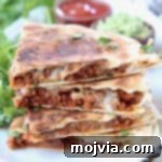 Stacked up slices of soy chorizo quesadilla on plate