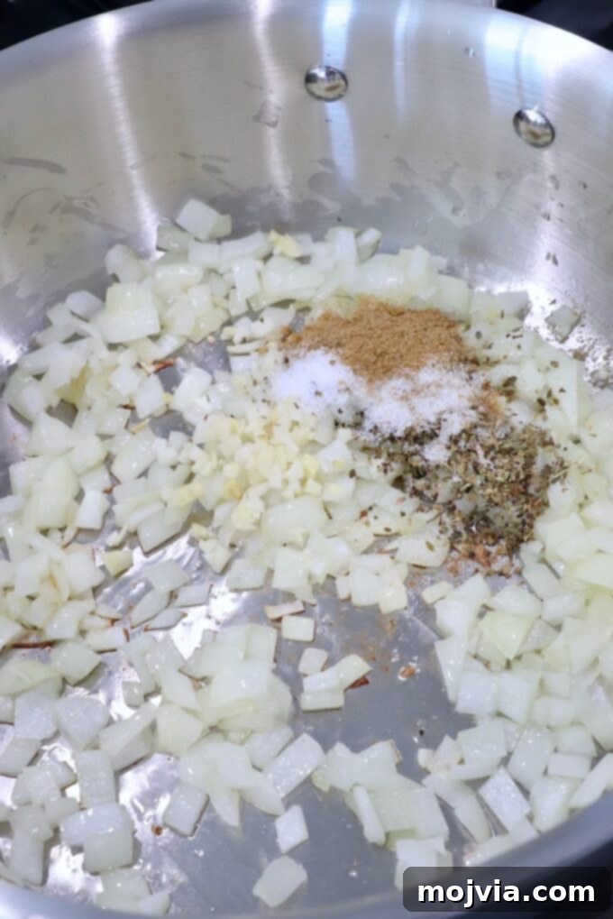 Smoky Chipotle Chicken Tinga 4 diced onions and garlic in pan with spices