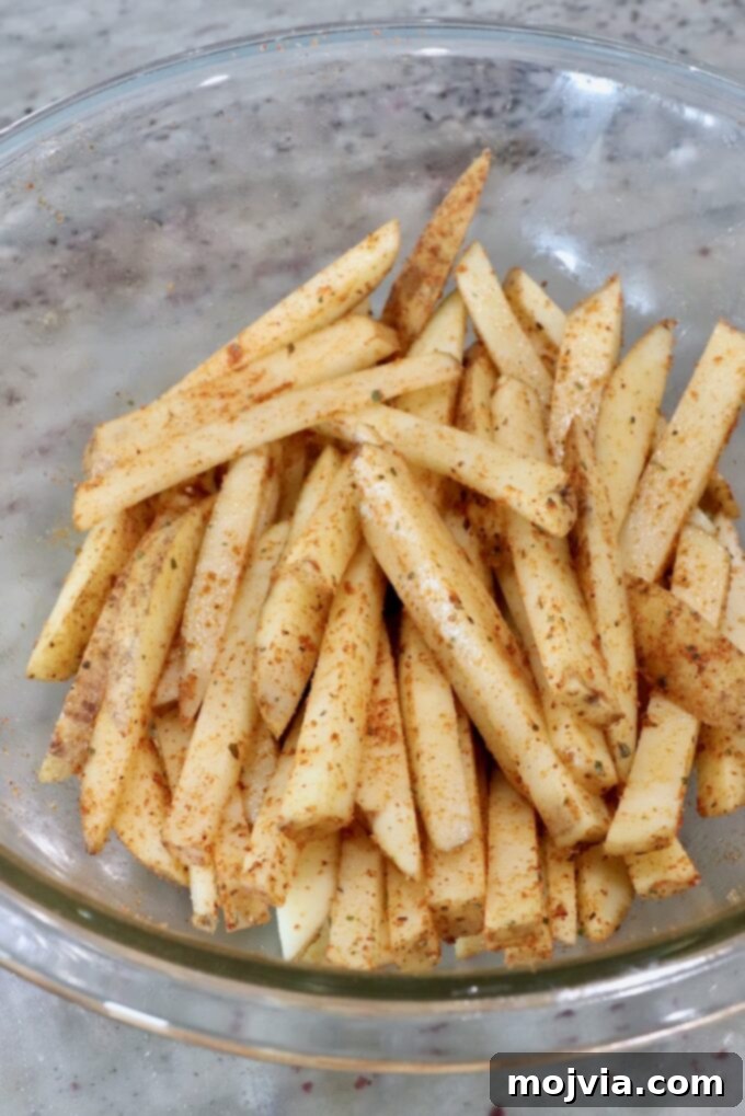 Ultimate Grilled Steak Fries 7 seasoned potatoes sliced into fries in glass bowl