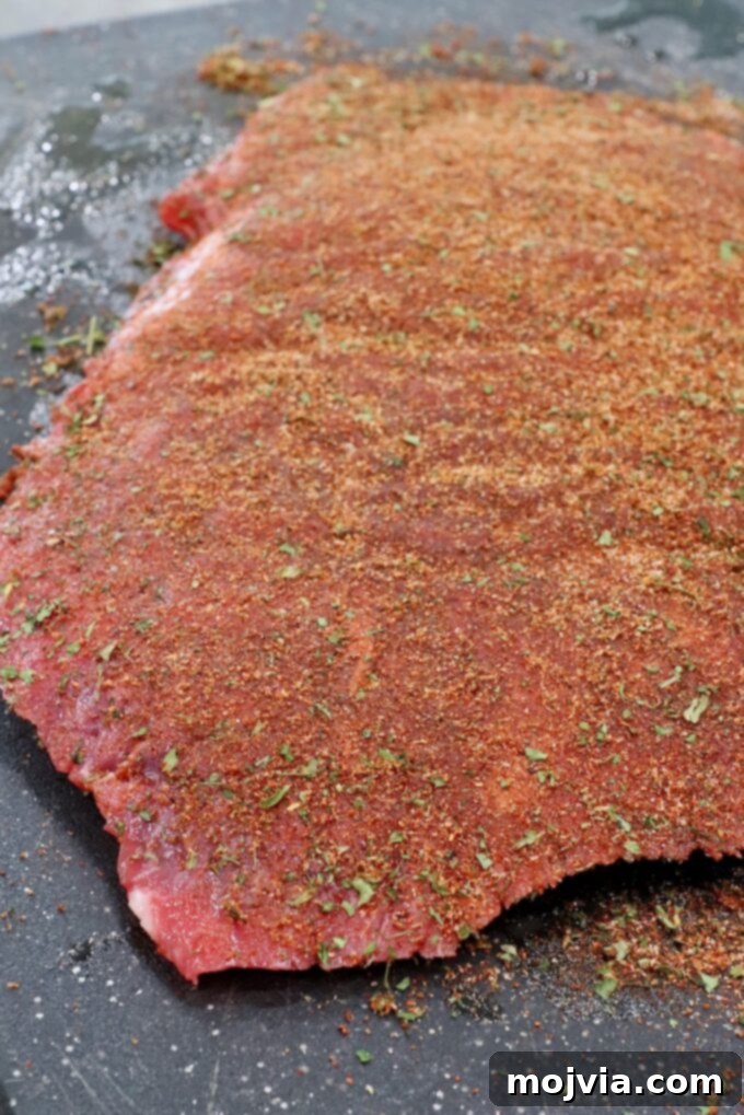 Crispy Beef Taquitos 4 flank steak covered in seasoning on cutting board