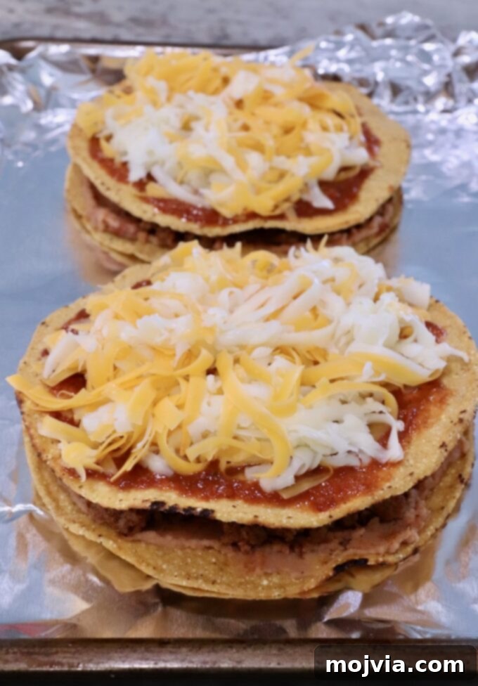 uncooked Mexican pizzas on a foil-lined baking sheet