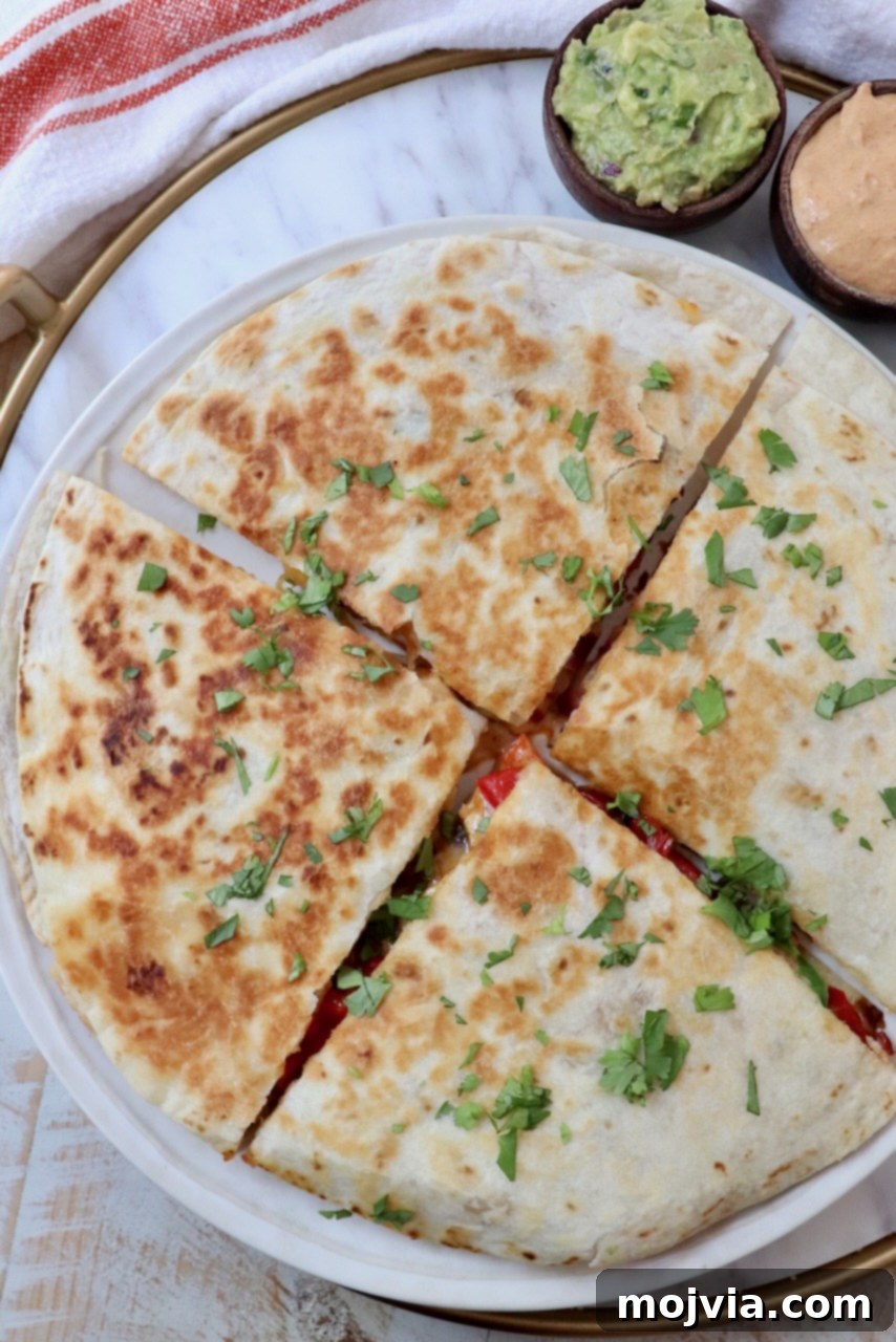 Golden Grilled Chicken Quesadillas 2 chicken quesadilla sliced into quarters on a plate