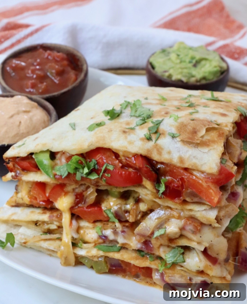 Golden Grilled Chicken Quesadillas 11 stacked up chicken and fajita veggie quesadilla on a plate