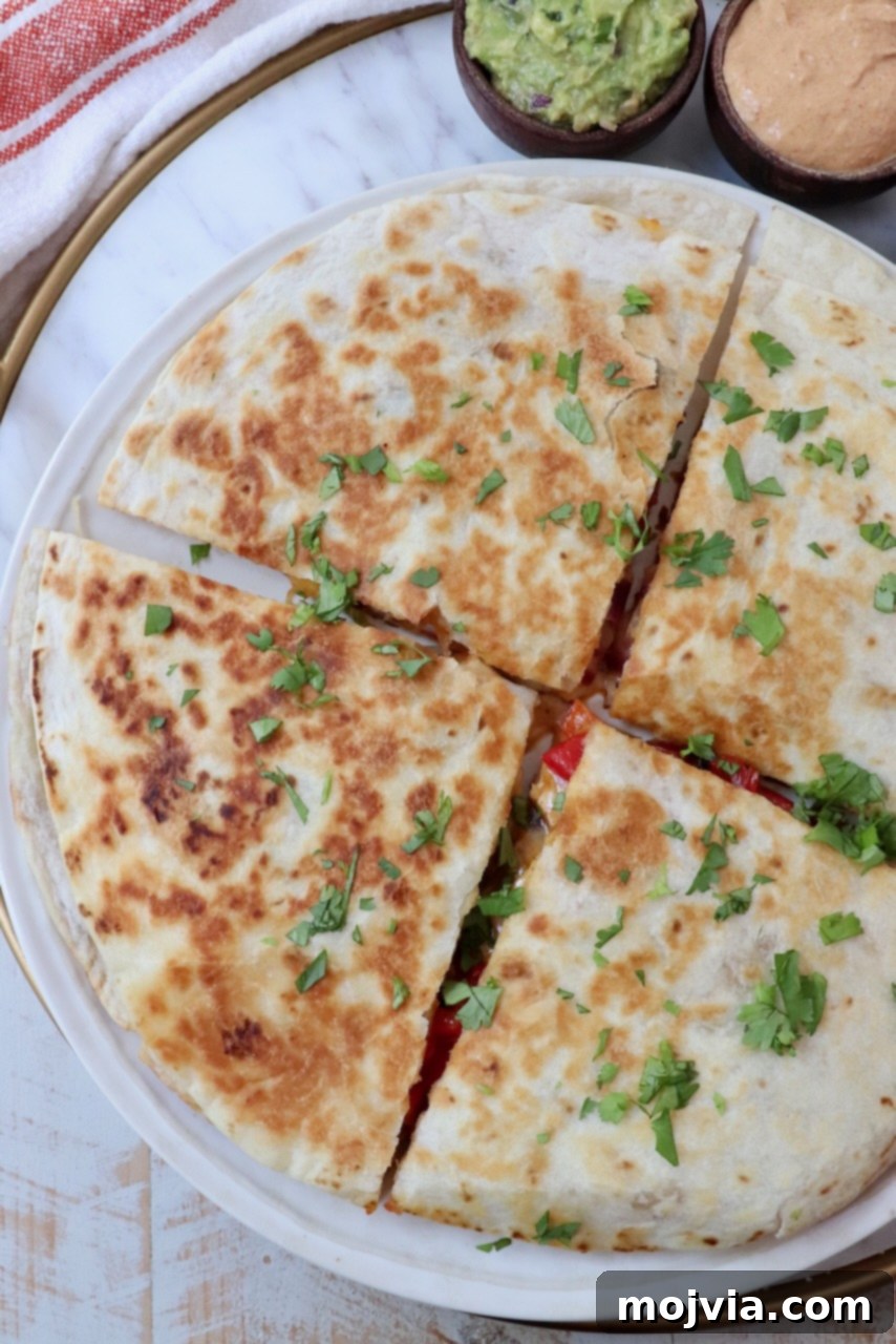 Golden Grilled Chicken Quesadillas 12 chicken quesadilla sliced into quarters on a plate