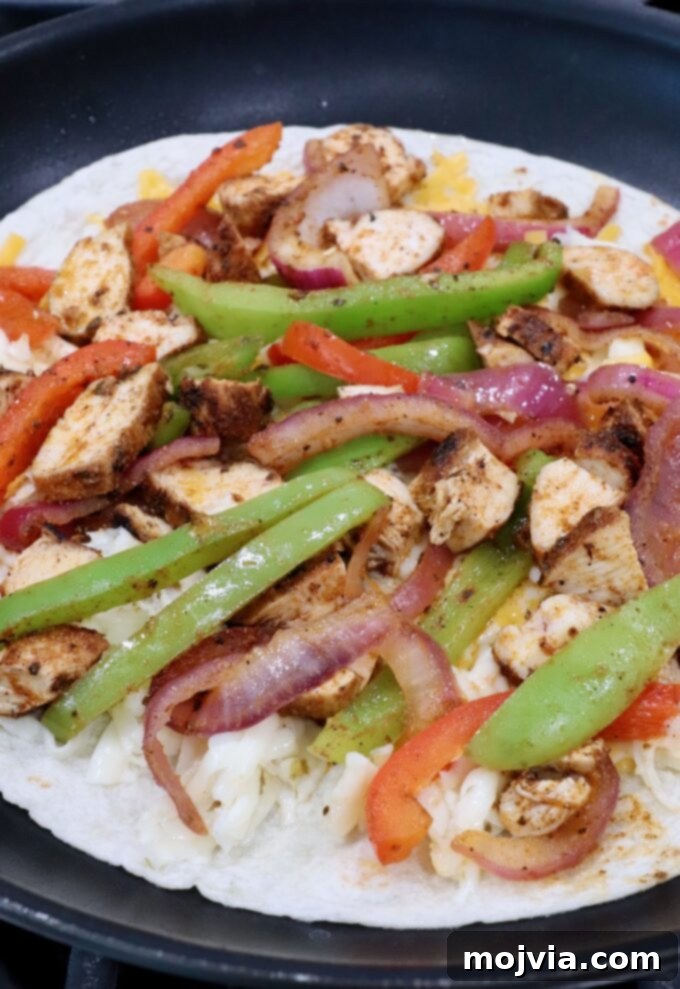Golden Grilled Chicken Quesadillas 8 tortilla in a skillet topped with sliced fajita veggies and diced chicken