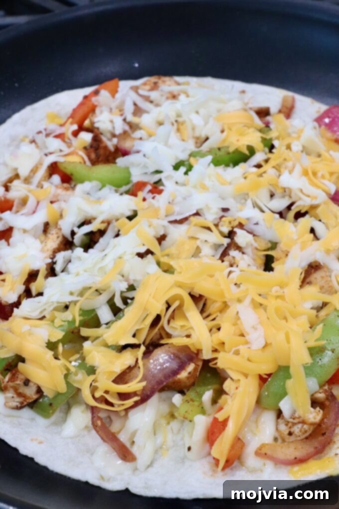 Golden Grilled Chicken Quesadillas 9 tortilla in skillet topped with sliced fajita veggies, diced chicken and shredded cheese
