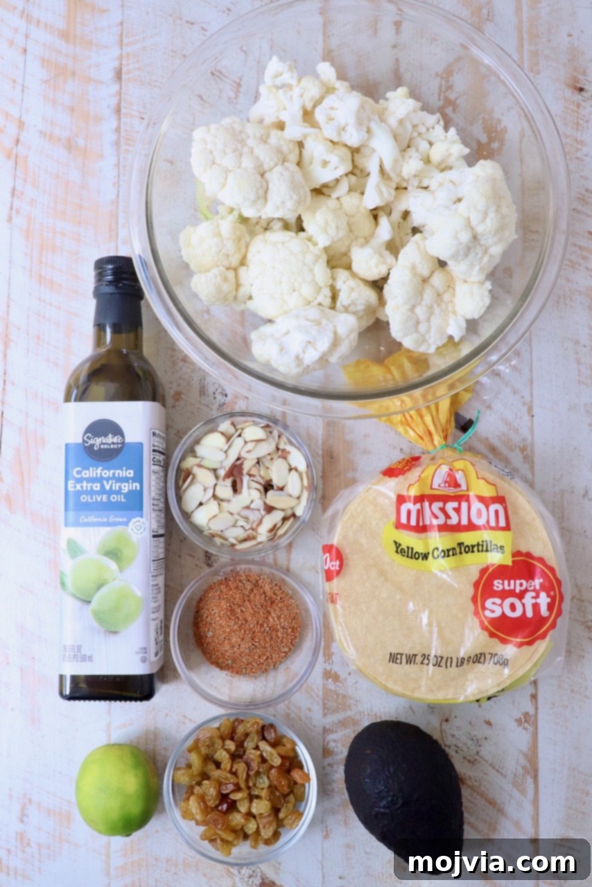 Spicy Cauliflower Tacos 3 Fresh ingredients for cauliflower tacos laid out on a white wooden board