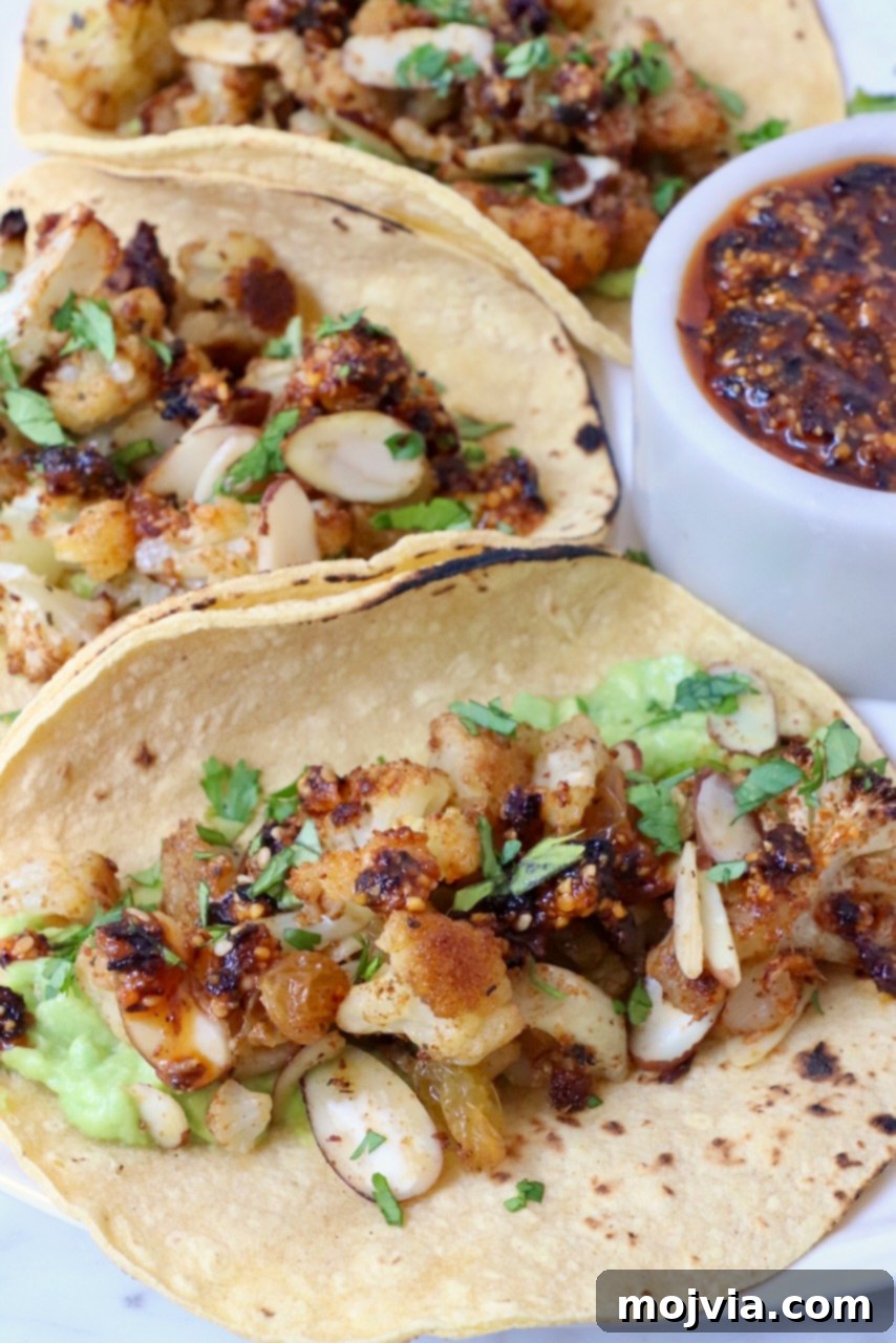 Spicy Cauliflower Tacos 7 Cauliflower tacos artfully arranged on a plate with a side of salsa