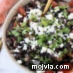 Traditional Mexican Black Beans 8 black beans in bowl, topped with crumbled cheese and fresh cilantro