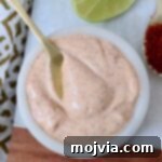 Zesty Chili Lime Vinaigrette 7 chili lime dressing in a white bowl with a gold spoon