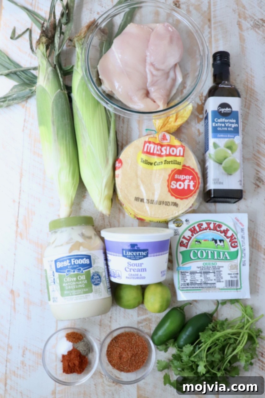 Elote Chicken Tacos 3 A vibrant flat lay showing all the fresh ingredients needed for chicken street corn tacos, beautifully arranged on a rustic white wooden board, ready for prep