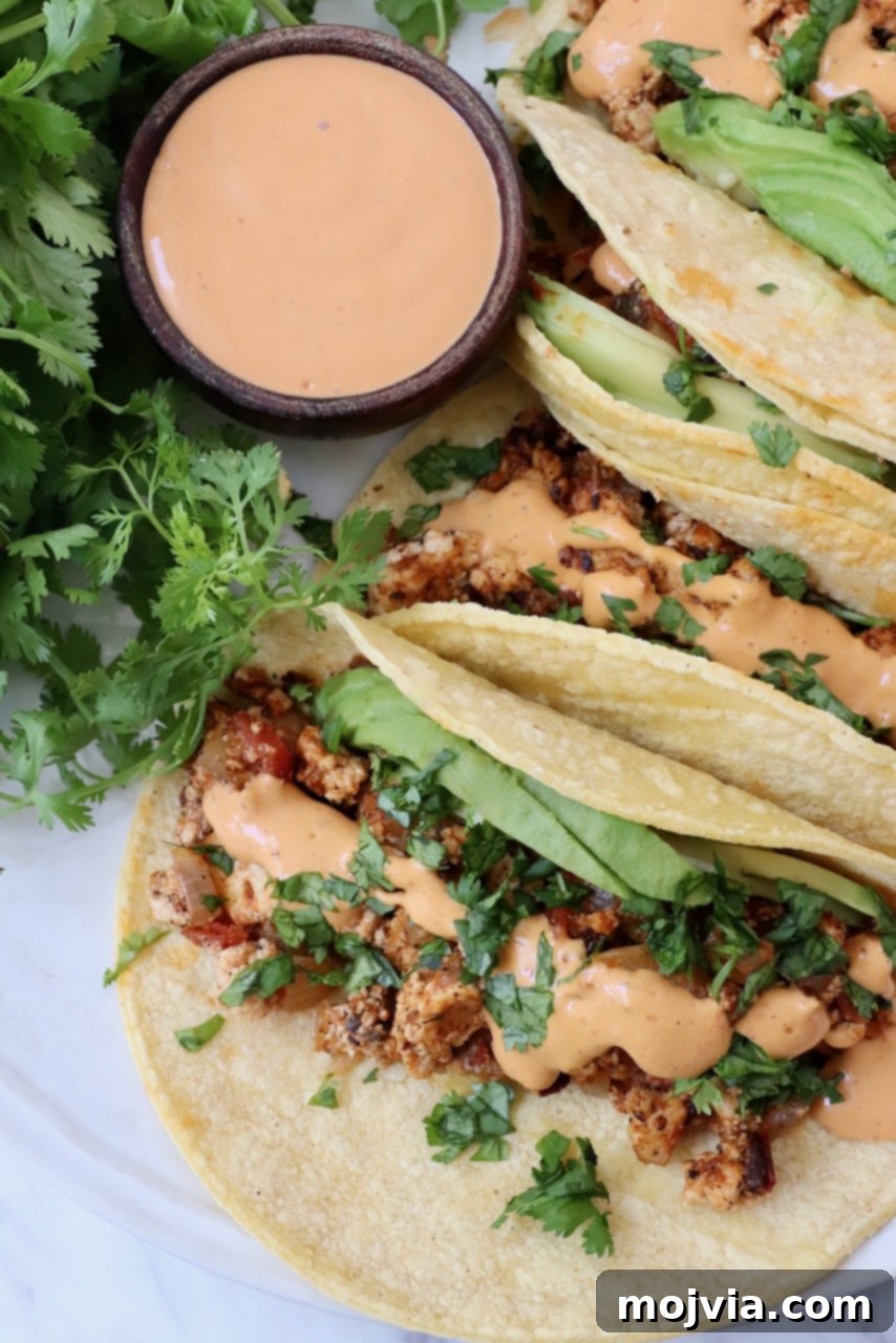 crumbled tofu tacos on plate topped with chipotle sauce