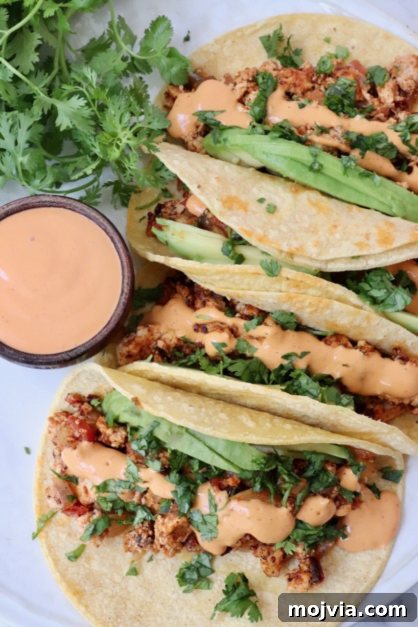 crumbled tofu tacos topped with chipotle sauce on a plate