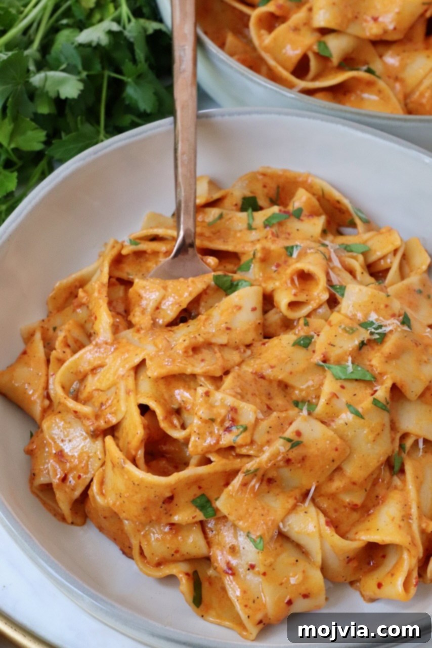 Calabrian Fire Pasta 2 pappardelle pasta tossed with nduja sauce in bowl with fork