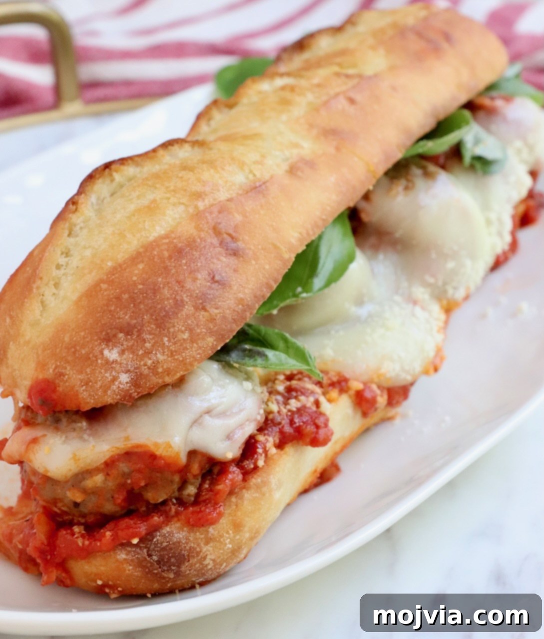 A delicious Italian meatball sub artfully arranged on a plate with garnishes, ready to be enjoyed.