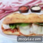 A tantalizing meatball sub sandwich on a plate, showcasing its golden crust and melted cheese.