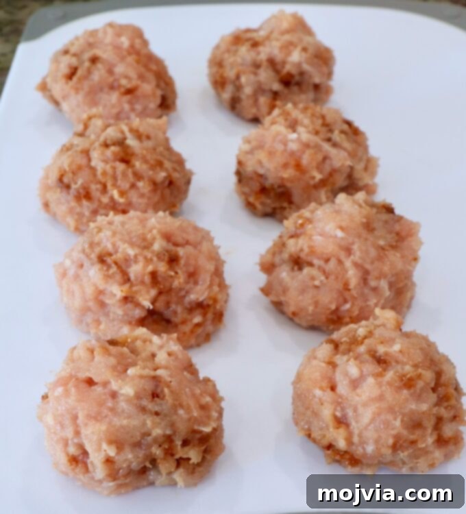 Spicy Buffalo Chicken Smash Burger 5 seasoned balls of ground chicken on a white cutting board