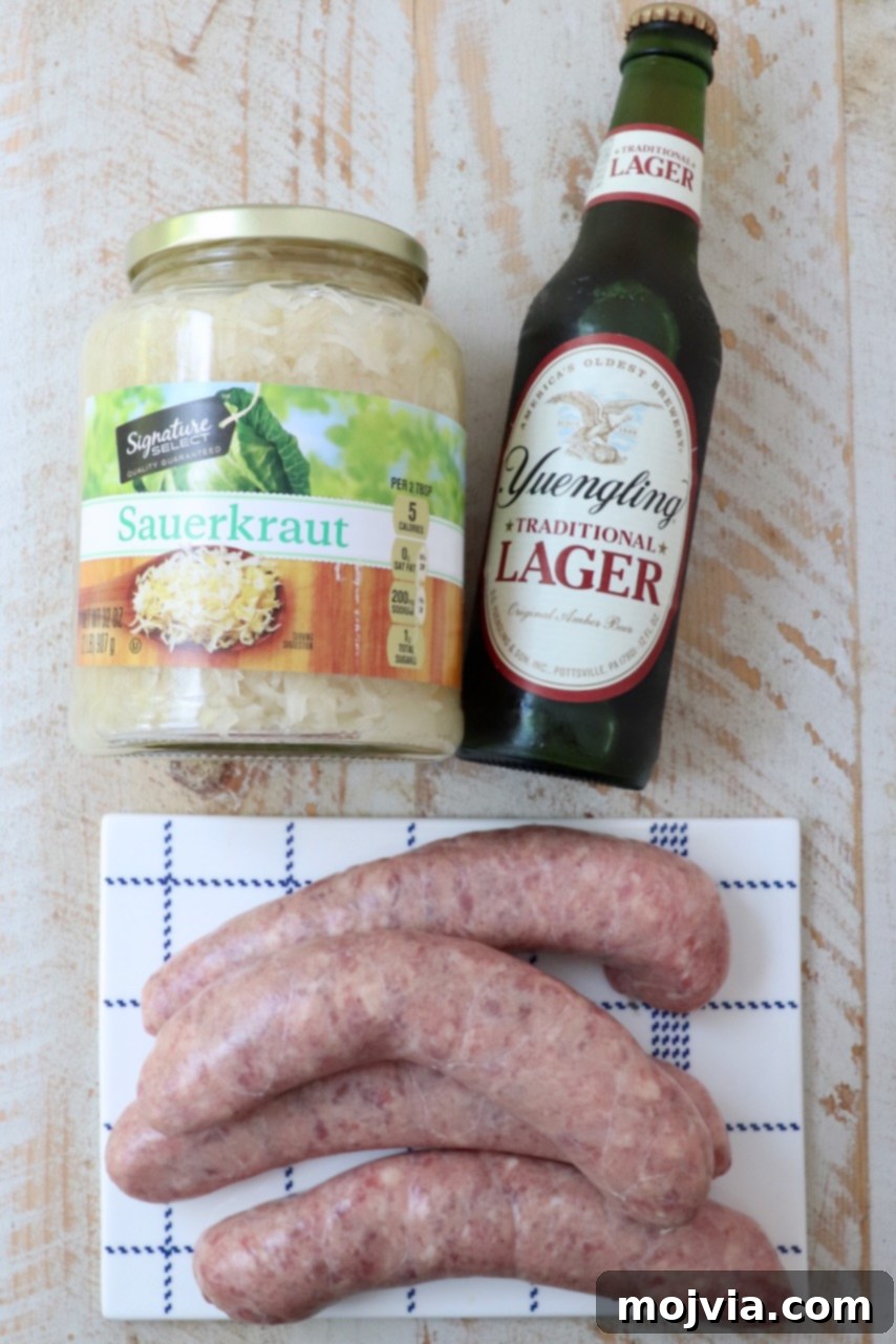 A selection of fresh bratwurst sausages, a bottle of beer, and a jar of sauerkraut laid out on a white wooden board, ready for cooking.