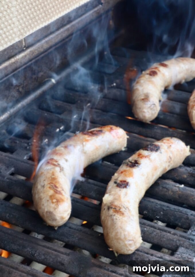 Golden-brown grilled bratwurst sausages with visible char marks, perfectly seared on a hot grill.