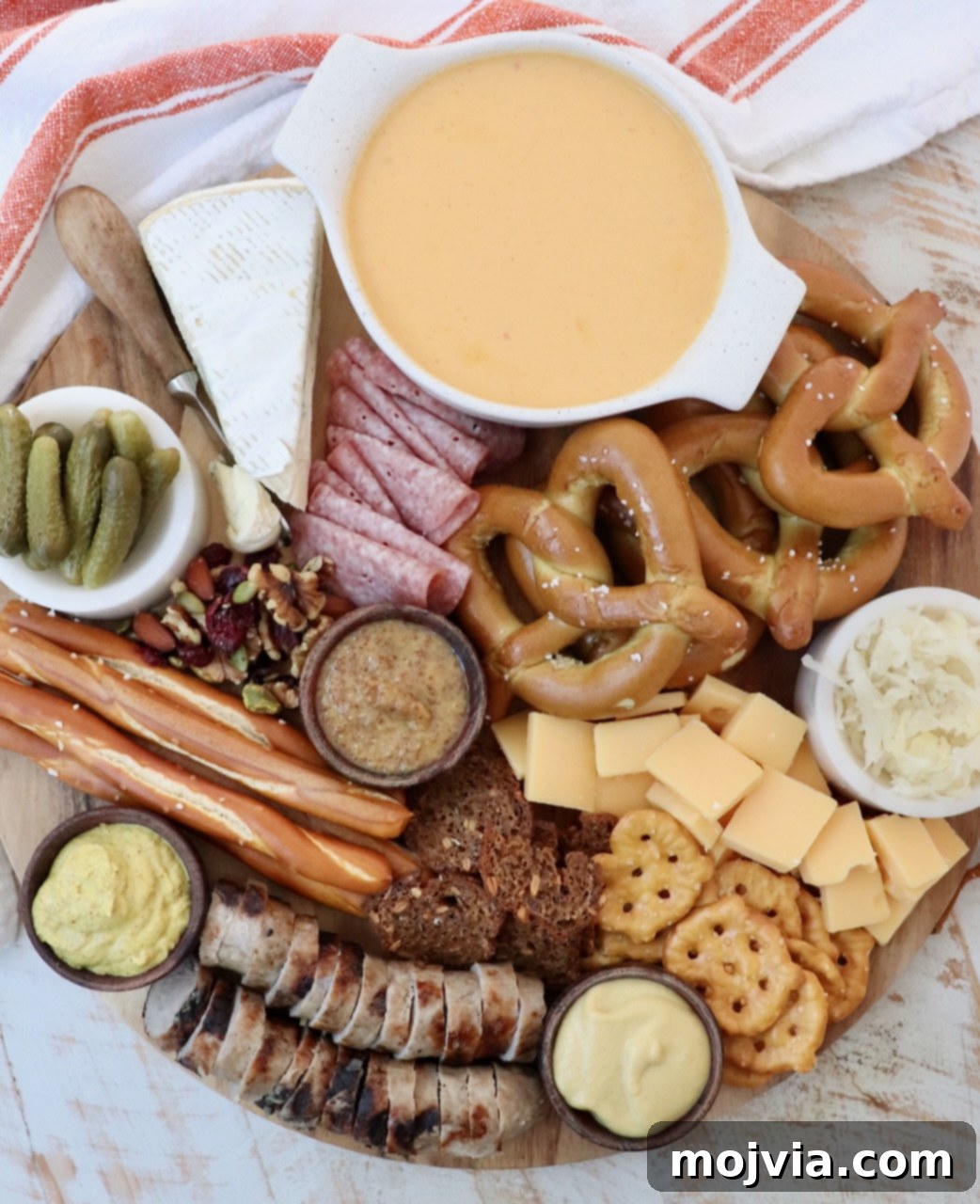 Oktoberfest charcuterie board filled with cheese, meats and pretzels