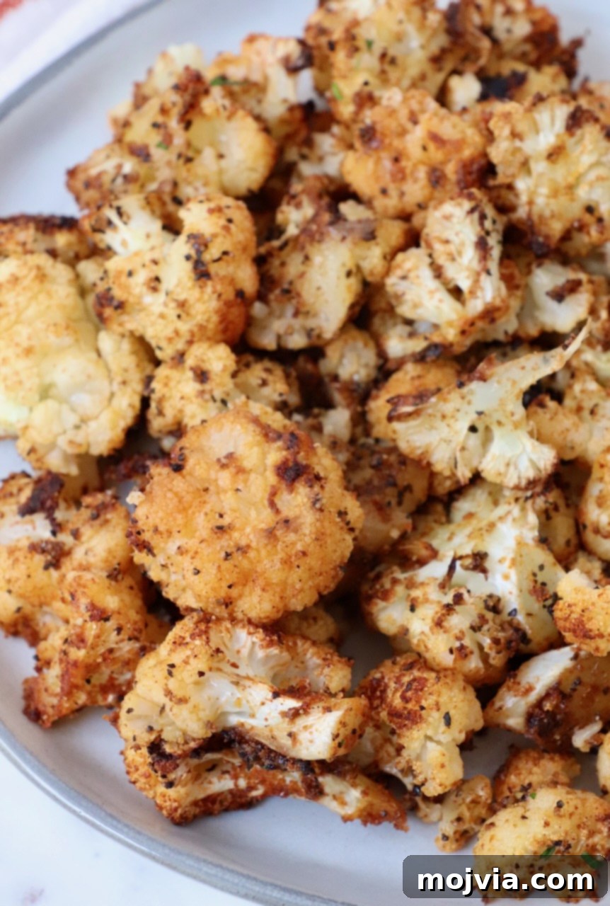 Golden Roasted Cauliflower 2 A plate of perfectly roasted cauliflower florets, golden brown and garnished, ready to be served.