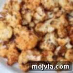 Crispy seasoned roasted cauliflower on a plate, ready to be enjoyed.