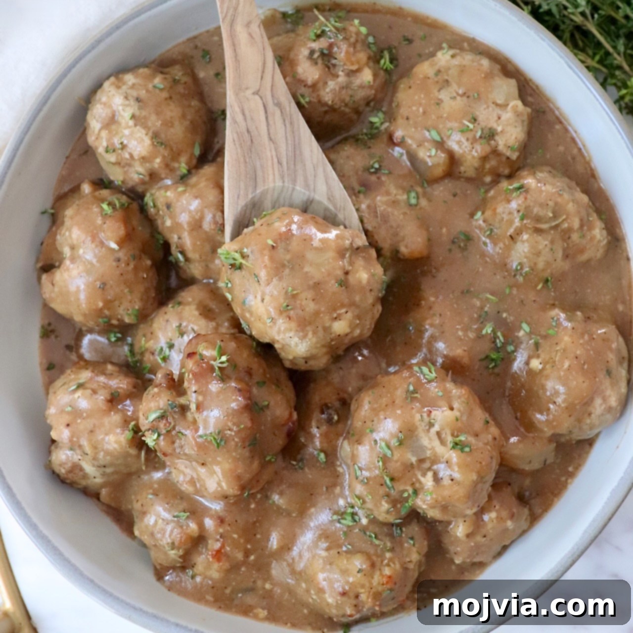 turkey meatballs in gravy in a bowl with a spoon