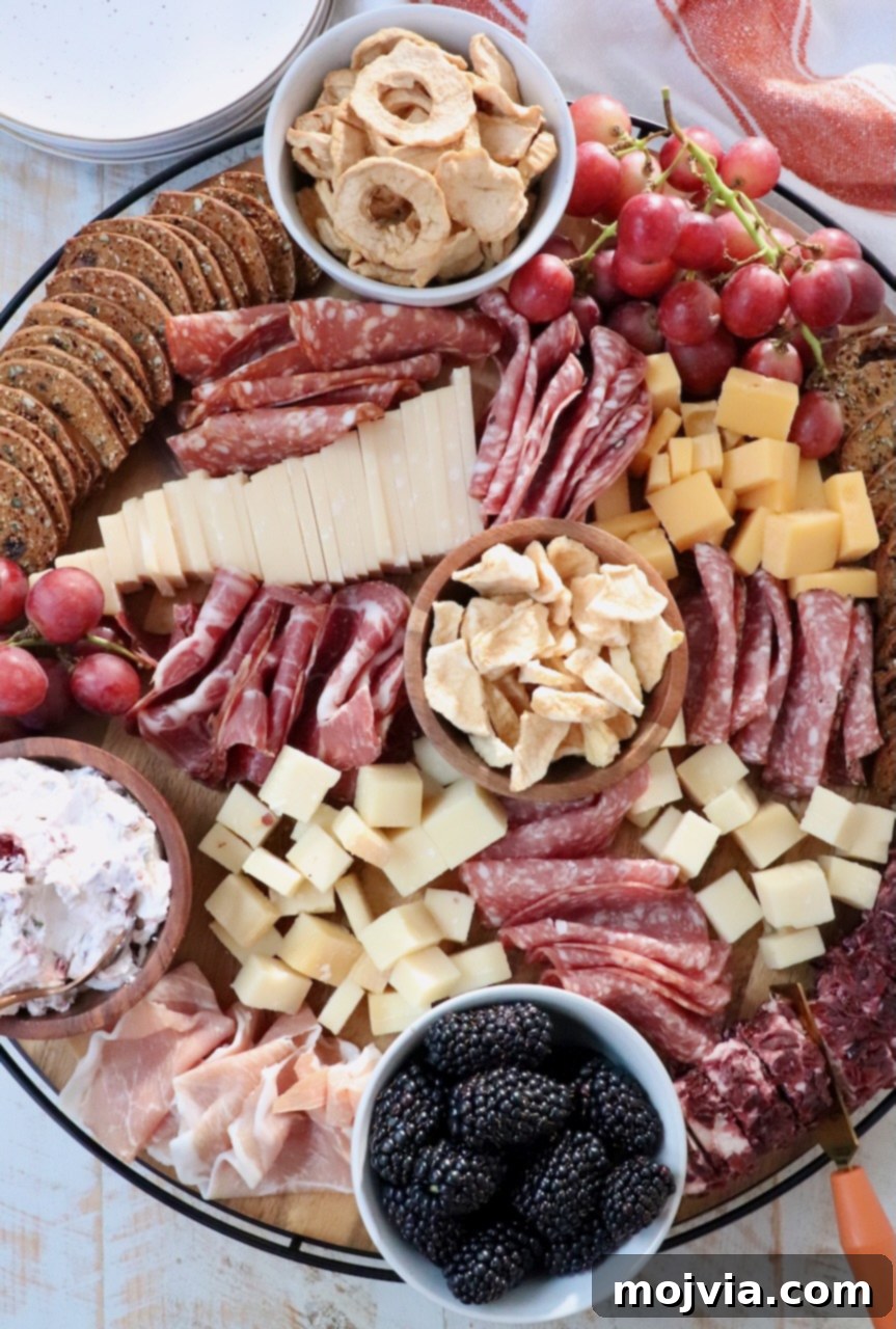 Autumn's Bounty Board 2 A beautifully arranged Fall Charcuterie Board featuring cured meats, an assortment of cheeses, vibrant seasonal fruits, and various crackers, perfect for autumn entertaining.