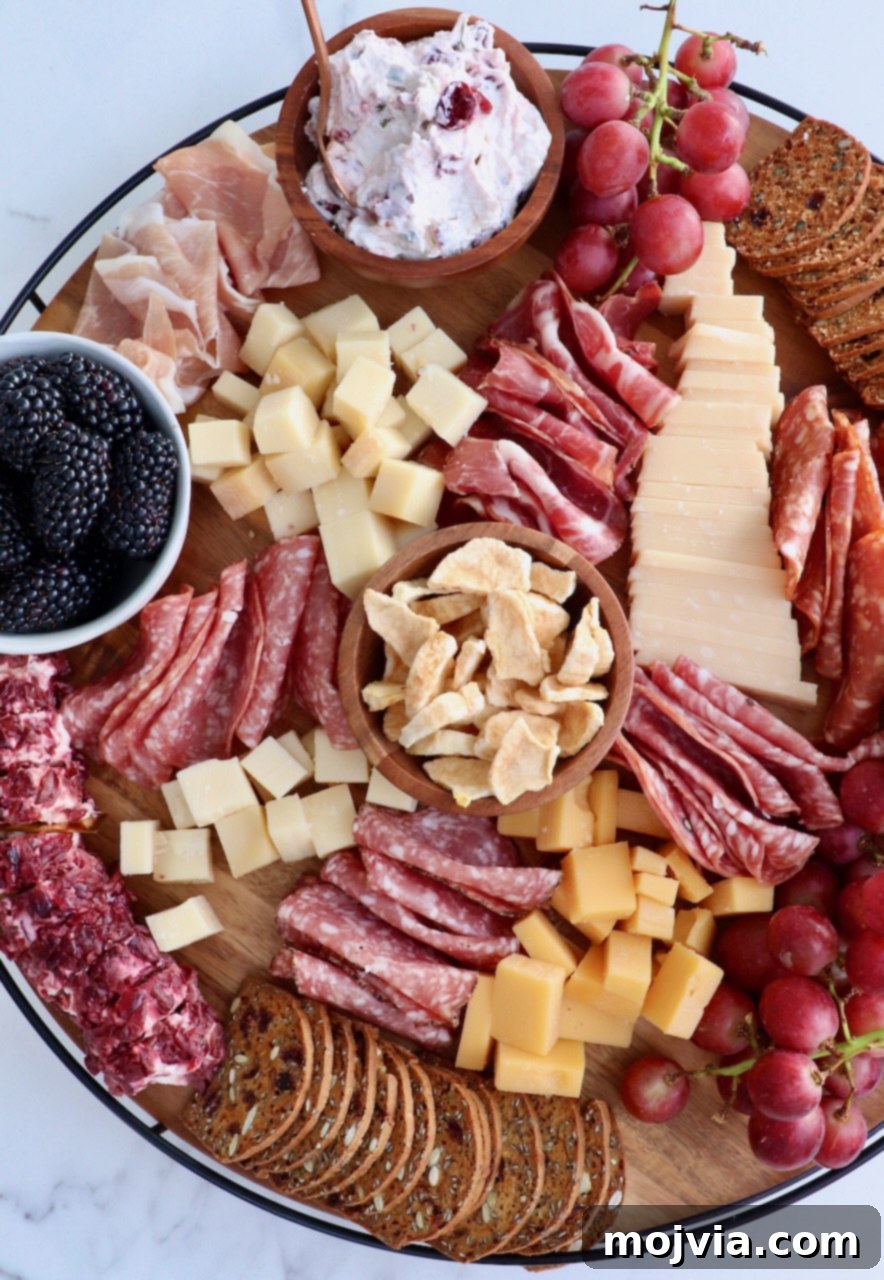 Autumn's Bounty Board 4 A vibrant and fully assembled Fall Charcuterie Board showcasing an abundance of cheeses, various cured meats, dried and fresh fruits, crackers, and dips, artfully arranged on a round wooden platter.