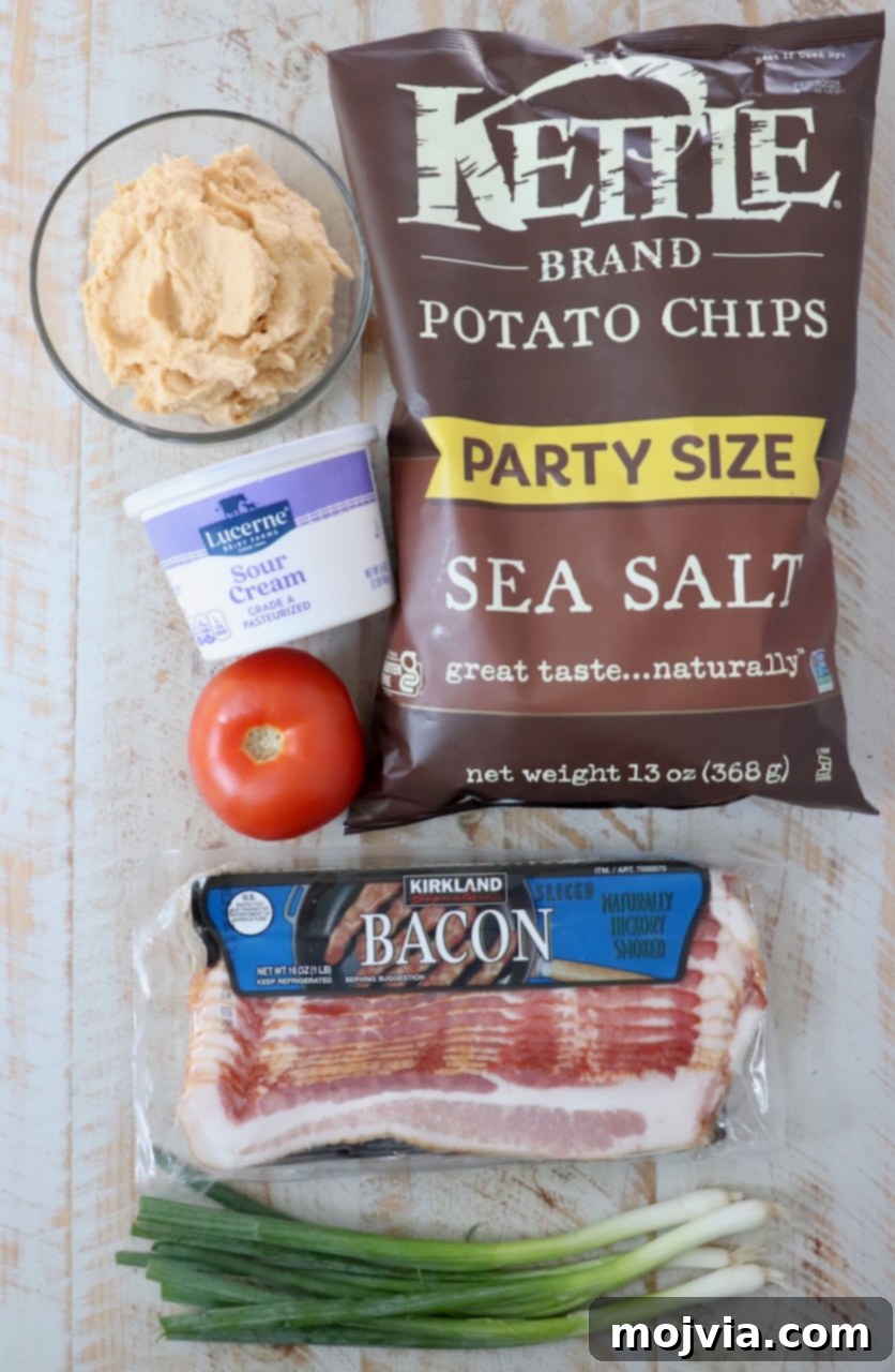 Emerald Potato Nachos 3 A vibrant flat lay showcasing all the fresh ingredients needed for Irish nachos laid out on a rustic white wooden board.
