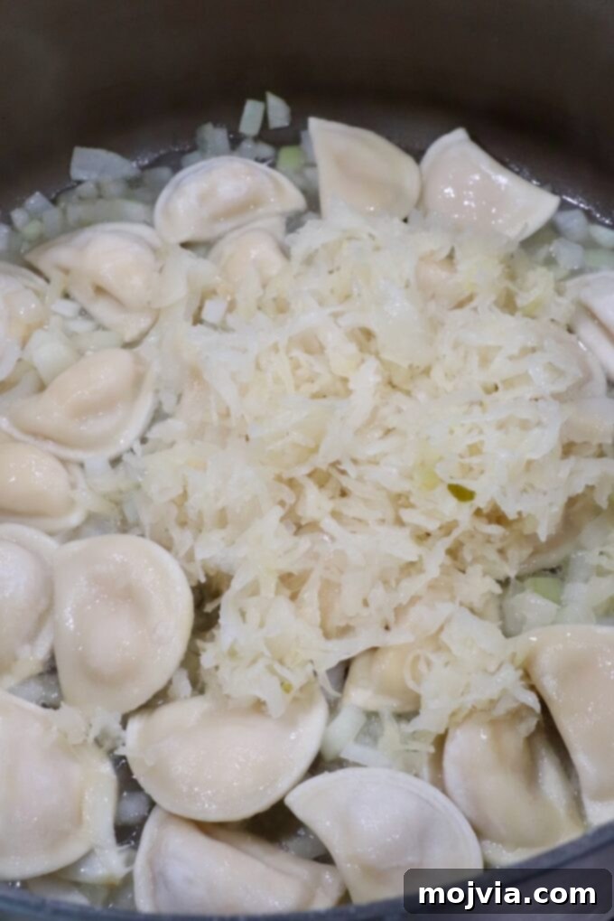 Hearty Pierogi Soup 5 Sauerkraut being added to a pot with sautéed onions and mini pierogis.