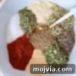 Ultimate Beef Stew Spice Mix 6 dried herbs and spices separated in a bowl with a spoon